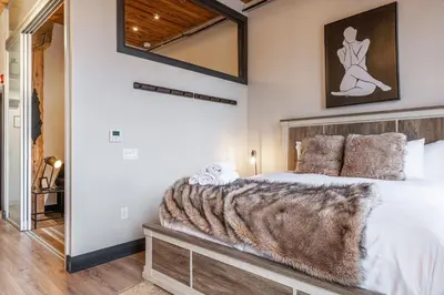 a bedroom with a bed with a faux fur blanket at Bradshaw Lofts The Brixton King Suite in Stratford