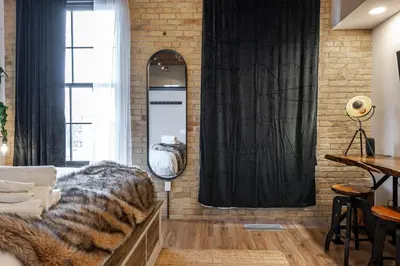 a living room with a couch and a brick wall at Bradshaw Lofts The Brixton King Suite in Stratford