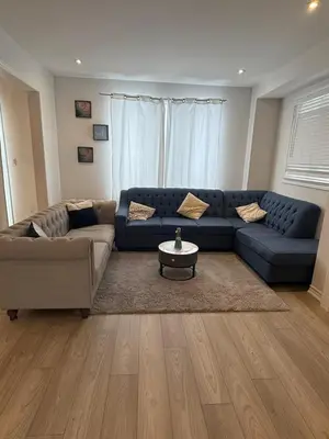 a living room with a blue couch and a table at Short Term Cozy Stay in Beautiful Fergus in Fergus