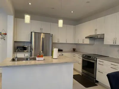 a kitchen with white cabinets and stainless steel appliances at Short Term Cozy Stay in Beautiful Fergus in Fergus