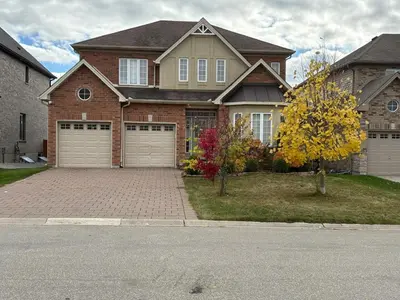 a brick house with two garage doors on a driveway at Entire home in London, Ontario, Canada in London