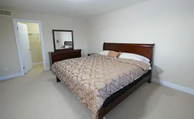 a bedroom with a large bed and a mirror at Entire home in London, Ontario, Canada in London