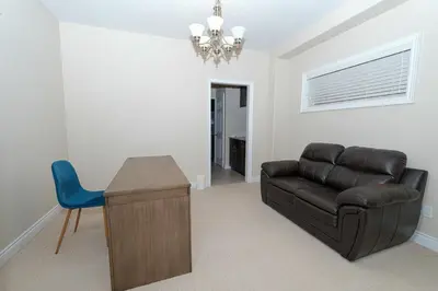 a living room with a leather couch and a desk at Entire home in London, Ontario, Canada in London