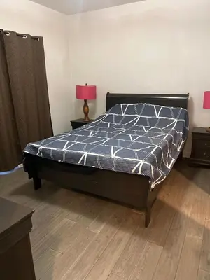 a bedroom with a bed with a blue comforter at Places to stay bbq ac heat parking wiffi in Kawartha Lakes