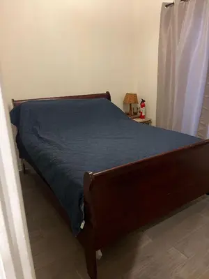 a bed in a bedroom with a blue comforter at Places to stay bbq ac heat parking wiffi in Kawartha Lakes