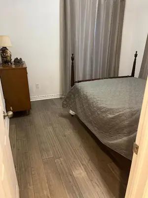 a bedroom with a bed and a wooden floor at Places to stay bbq ac heat parking wiffi in Kawartha Lakes
