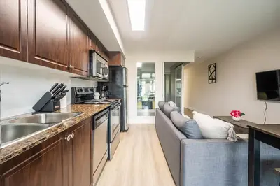 a kitchen with a couch and a sink in a room at Modern 1Bedroom Condo with Balcony Downtown Toronto in Toronto