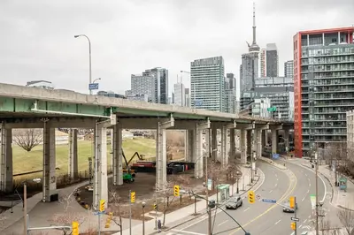 a bridge over a highway in a city with buildings at Modern 1Bedroom Condo with Balcony Downtown Toronto in Toronto