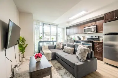 a living room with a couch and a kitchen at Modern 1Bedroom Condo with Balcony Downtown Toronto in Toronto