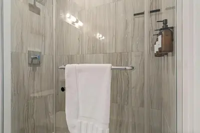 a bathroom with a shower with a white towel at Your Friday Harbour Escape Awaits! in Innisfil