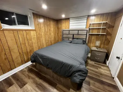 a bedroom with a bed in a room with wooden walls at Prime Location 3Bedrooms, 2 Bath, Basement Apartment with parking- Streetsville Area, Close to Transit- Sleeps 6 in Mississauga