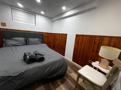a bedroom with a bed and a chair and a lamp at Prime Location 3Bedrooms, 2 Bath, Basement Apartment with parking- Streetsville Area, Close to Transit- Sleeps 6 in Mississauga