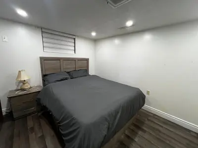 a bedroom with a bed and a night stand with a lamp at Prime Location 3Bedrooms, 2 Bath, Basement Apartment with parking- Streetsville Area, Close to Transit- Sleeps 6 in Mississauga