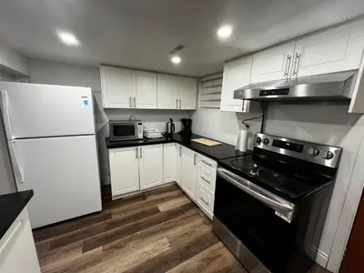 a kitchen with white cabinets and a black appliance at Prime Location 3Bedrooms, 2 Bath, Basement Apartment with parking- Streetsville Area, Close to Transit- Sleeps 6 in Mississauga