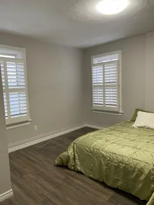 a bedroom with two windows and a bed in it at Home Base Executive Rental in Hamilton in Hamilton