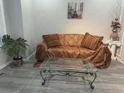 a living room with a couch and a glass coffee table at Home Base Executive Rental in Hamilton in Hamilton