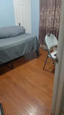 a bedroom with a bed and a chair next to a window at Space Share Accommodation East York Budget Friendly in Toronto