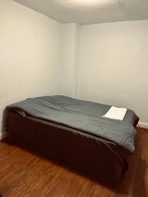 a bed in a small room with a wooden floor at Space Share Accommodation East York Budget Friendly in Toronto