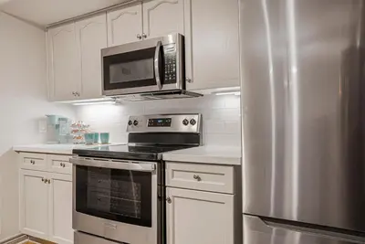 a kitchen with a stainless steel refrigerator and microwave at Luxury Jacuzzi Suite with Sauna & Heated Pool in Shanty Bay