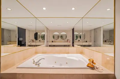 a large bathroom with a tub with mirrors at Luxury Jacuzzi Suite with Sauna & Heated Pool in Shanty Bay