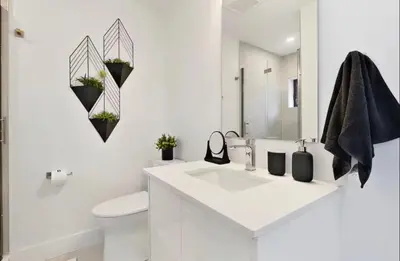 a white bathroom with a sink and a toilet at 2Bdrm Penthouse Close To Falls With Parking in Niagara Falls