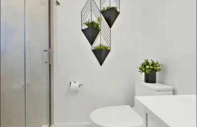 a white bathroom with a toilet and a glass shower at 2Bdrm Penthouse Close To Falls With Parking in Niagara Falls