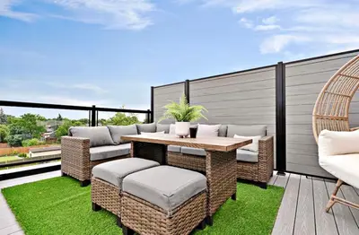 a patio with a table and chairs on a balcony at 2Bdrm Penthouse Close To Falls With Parking in Niagara Falls