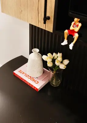 a book and a vase with flowers on a table at Central Getaway University of Toronto TTC Queen M in Toronto