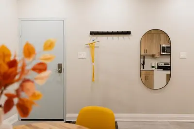 a dining room with a mirror and a yellow chair at Central Getaway University of Toronto TTC Queen M in Toronto