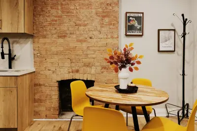 a dining room with a table and yellow chairs at Central Getaway University of Toronto TTC Queen M in Toronto