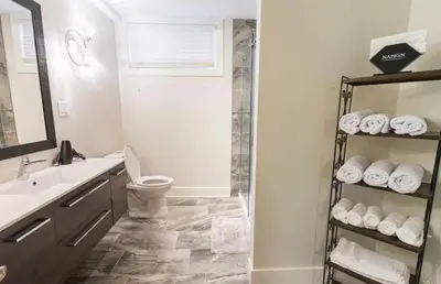 a bathroom with a shower and a toilet and a sink at Modern Cozy Executive Suite with Private Entrance in London