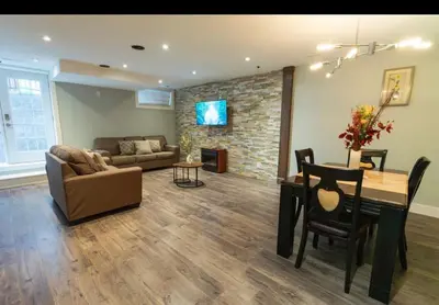 a living room with a table and a dining room at Modern Cozy Executive Suite with Private Entrance in London