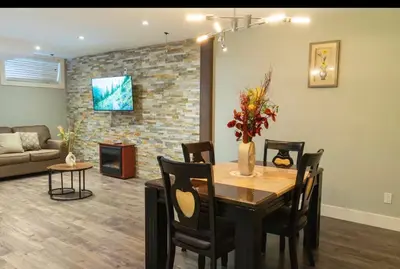 a living room with a dining room table and a couch at Modern Cozy Executive Suite with Private Entrance in London