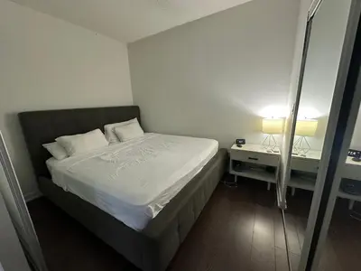 a small bedroom with a bed and a mirror at Luxury smart condo downtown Toronto in Toronto