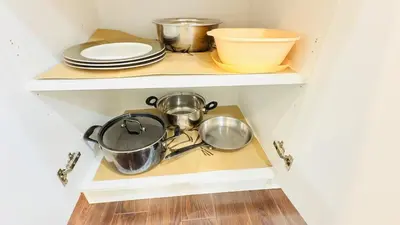 a kitchen shelf with pots and pans and plates at Newly Renovated Private Suite Separate Entrance in Richmond Hill