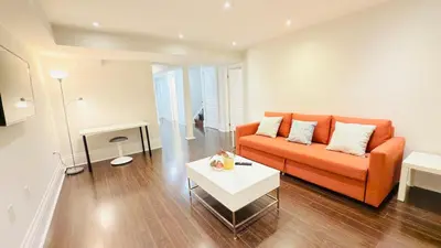 a living room with an orange couch and a table at Newly Renovated Private Suite Separate Entrance in Richmond Hill
