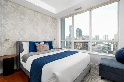 a bedroom with a bed and a large window at Comfort and Beauty in the heart of Tor | W Parking in Toronto