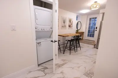 a kitchen with a washer and dryer and a table at Apartment Near Downtown Toronto & The Beaches in Toronto