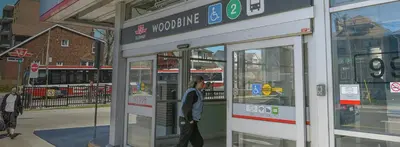 a man walking into a building with a bus at Apartment Near Downtown Toronto & The Beaches in Toronto