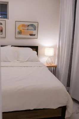a bedroom with a bed and a table with a lamp at Apartment Near Downtown Toronto & The Beaches in Toronto