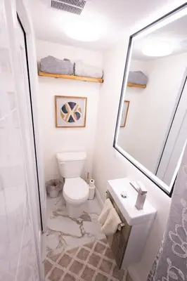 a bathroom with a toilet and a sink and a mirror at Apartment Near Downtown Toronto & The Beaches in Toronto