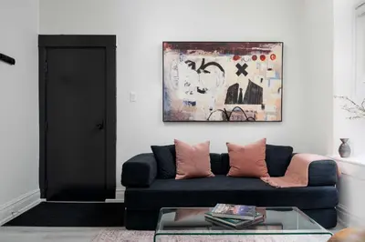 a living room with a blue couch with pink pillows at Stylish Roncesvalles Flat in Toronto