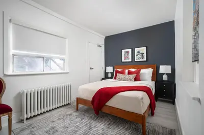 a bedroom with a large bed and a window at Stylish Roncesvalles Flat in Toronto