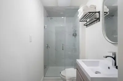 a bathroom with a shower and a toilet and a sink at Stylish Roncesvalles Flat in Toronto