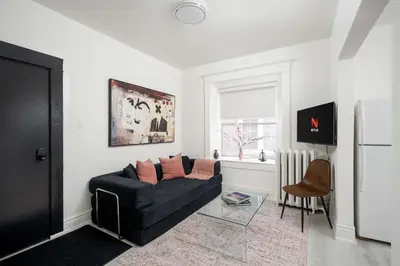a living room with a couch and a window at Stylish Roncesvalles Flat in Toronto