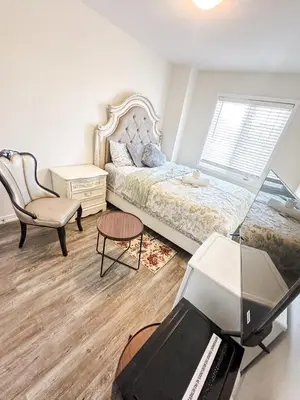 a bedroom with a bed and a chair and a desk at Quiet Haven in Oshawa