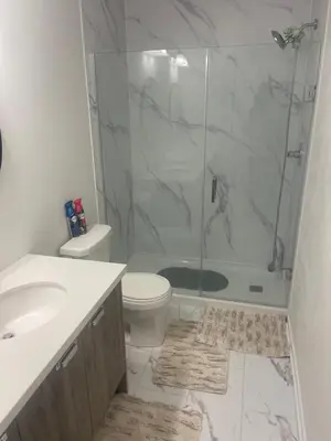 a bathroom with a shower and a toilet and a sink at Quiet Haven in Oshawa