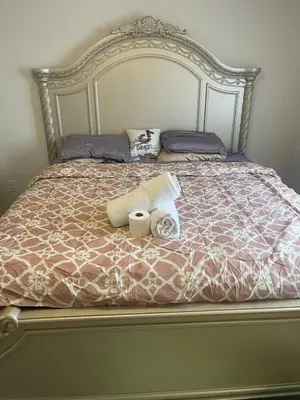 a bed with two rolls of towels and two pillows at Quiet Haven in Oshawa