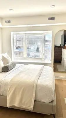 a large bed in a bedroom with a large window at Bright & Cozy Private Studio Apartment in Toronto