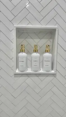 three perfume bottles on a shelf in a wall at Bright & Cozy Private Studio Apartment in Toronto